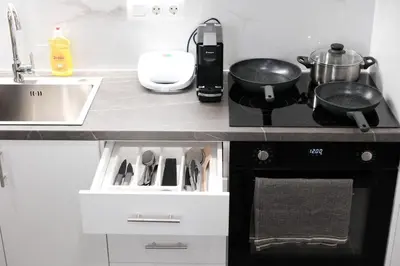 a kitchen with a stove and a sink with pots and pans at Cozy Home With Cooking in Piraeus