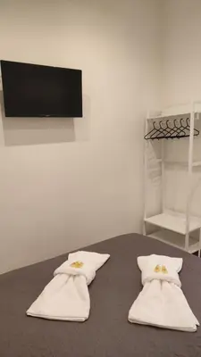 a table with two white towels and a tv on a wall at Marilyn Residence II in Athens
