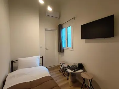 a bedroom with a bed and a television on the wall at Marilyn Residence II in Athens