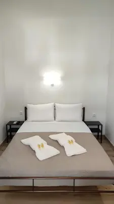 a bed with two white towels on top of it at Marilyn Residence II in Athens