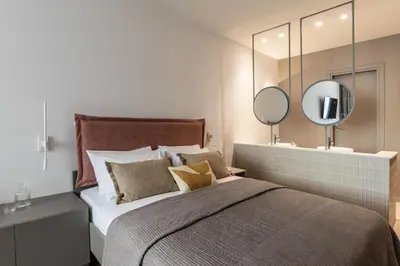 a bedroom with a large bed and a mirror at Celestial Athens Suites at Praxitelous in Athens