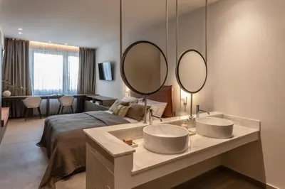 a bedroom with two sinks and a bed with two mirrors at Celestial Athens Suites at Praxitelous in Athens