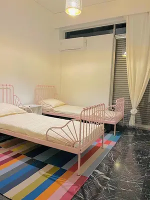 two beds in a room with a colorful rug at Kallithea Nest by Mancris in Athens