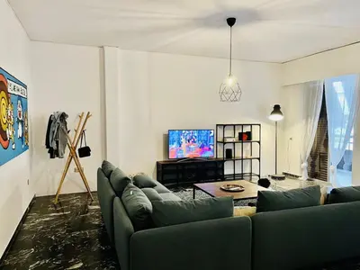 a living room with a couch and a flat screen tv at Kallithea Nest by Mancris in Athens