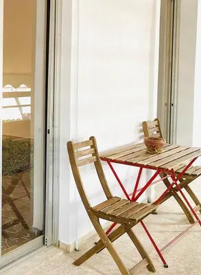 a wooden chair sitting next to a table on a porch at Kallithea Nest by Mancris in Athens