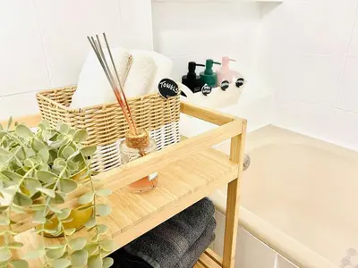 a bathroom with a bamboo shelf next to a bath tub at Kallithea Nest by Mancris in Athens