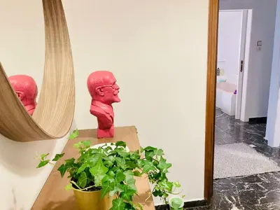 a red statue sitting on a table next to a mirror at Kallithea Nest by Mancris in Athens