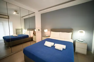 a bedroom with a blue bed with two white pillows at Kolonaki Xanthipou 7-9 by Zeussuites in Athens