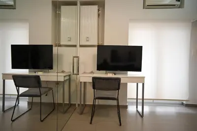 a desk with two monitors and two chairs in a room at Kolonaki Xanthipou 7-9 by Zeussuites in Athens