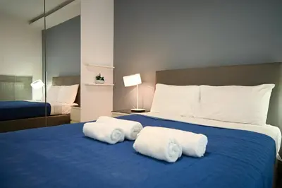a bedroom with a blue bed with towels on it at Kolonaki Xanthipou 7-9 by Zeussuites in Athens