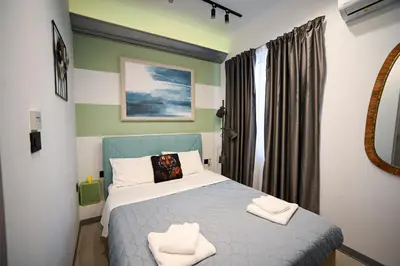 a bedroom with a bed with two towels on it at Hermes Suite Klathmonos by Zeussuites in Athens
