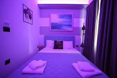 a purple bedroom with a bed with two pink pillows at Hermes Suite Klathmonos by Zeussuites in Athens
