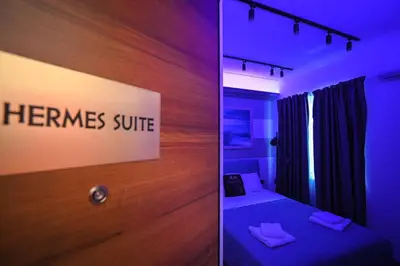 a bedroom with a bed and a sign that reads hermes suite at Hermes Suite Klathmonos by Zeussuites in Athens