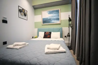 a bedroom with a bed with towels on it at Hermes Suite Klathmonos by Zeussuites in Athens