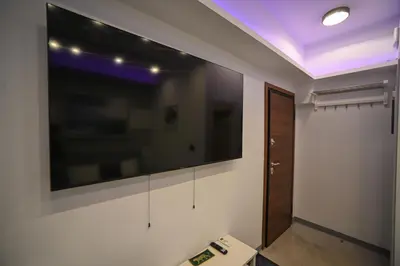 a room with a large flat screen tv on the wall at Hermes Suite Klathmonos by Zeussuites in Athens