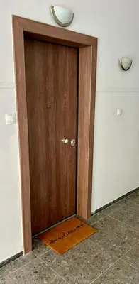 a wooden door in a room with a door mat at Elaion guest house in Athens
