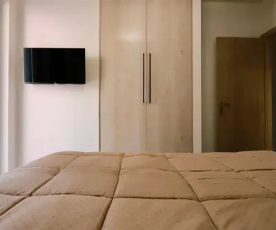 a bedroom with a bed with a television on the wall at Elaion guest house in Athens