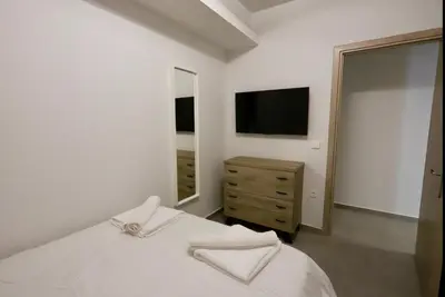 a bedroom with a bed and a mirror and a television at Elaion guest house in Athens