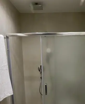 a shower with a glass door in a bathroom at Elaion guest house in Athens