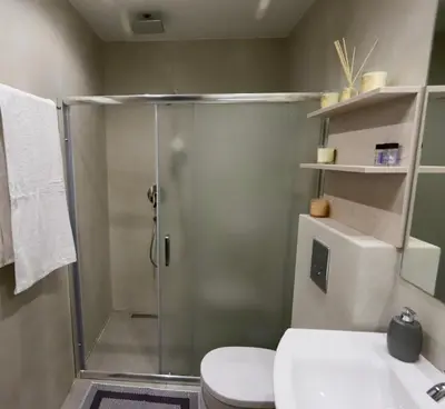 a bathroom with a shower with a toilet and a sink at Elaion guest house in Athens