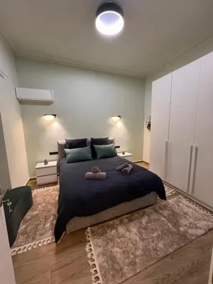 a bedroom with a large bed with two towels on it at Cozy and modern apartment in Athens