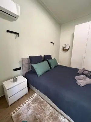 a bedroom with a large blue bed with a rug at Cozy and modern apartment in Athens