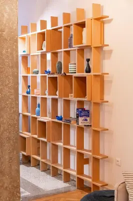 a book shelf in a living room with wooden shelves at Historic 2BR Oasis in Kolonaki in Athens
