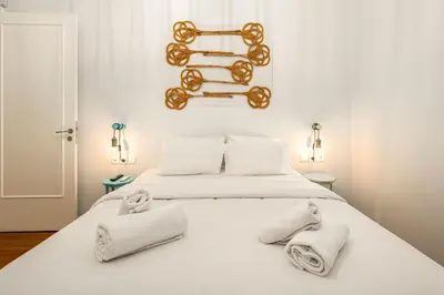 a bedroom with a white bed with towels on it at Historic 2BR Oasis in Kolonaki in Athens