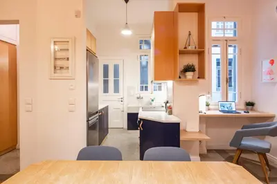 a kitchen with a table and chairs in a room at Historic 2BR Oasis in Kolonaki in Athens