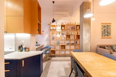 a kitchen and living room with a table and chairs at Historic 2BR Oasis in Kolonaki in Athens