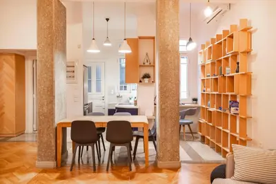a dining room and living room with a table and chairs at Historic 2BR Oasis in Kolonaki in Athens