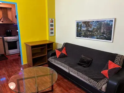 a living room with a black couch and a glass table at Modern Comfort Minutes from Plaka & Monastiraki in Athens