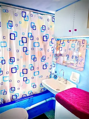 a bathroom with a sink and a shower curtain at Modern Comfort Minutes from Plaka & Monastiraki in Athens