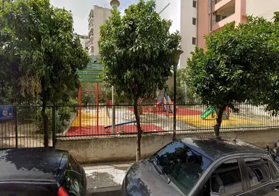 a car parked in front of a fence with trees at Modern Comfort Minutes from Plaka & Monastiraki in Athens