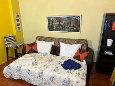 a bedroom with a bed with pillows and a painting at Modern Comfort Minutes from Plaka & Monastiraki in Athens