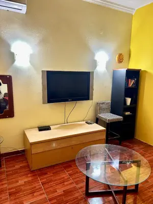 a living room with a flat screen tv and a table at Modern Comfort Minutes from Plaka & Monastiraki in Athens