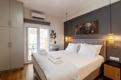 a bedroom with a large white bed and a window at Luxury Boutique Suite w Balcony 5 min Metro in Athens