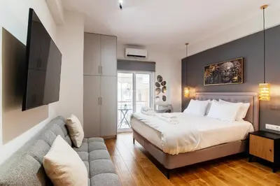 a bedroom with a bed and a couch at Luxury Boutique Suite w Balcony 5 min Metro in Athens