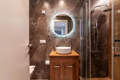 a bathroom with a sink and a shower with a mirror at Luxury Boutique Suite w Balcony 5 min Metro in Athens