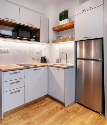 a kitchen with white cabinets and a stainless steel refrigerator at Luxury Boutique Suite w Balcony 5 min Metro in Athens