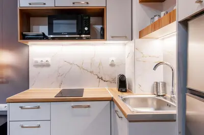 a small kitchen with a microwave and a sink at Luxury Boutique Suite w Balcony 5 min Metro in Athens