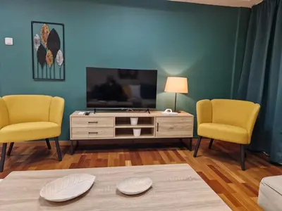 a living room with two yellow chairs and a television at AIOLOU st - 2 BDR APT - NetFlix in Athens