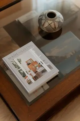 a glass table with a book and a vase on it at Beach Bliss Studio in Athens