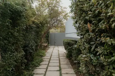 a stone path in a garden with bushes at Beach Bliss Studio in Athens