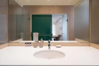 a bathroom with a sink and a large mirror at Beach Bliss Studio in Athens