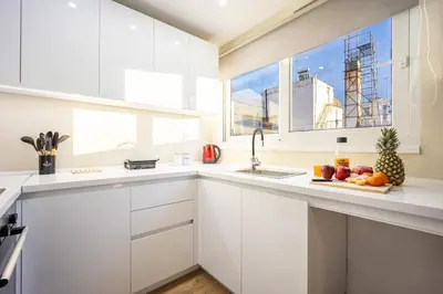 a kitchen with white cabinets and a plate of fruit at Spacious Rooftop Apt in Central Athens with Sunset Balcony in Athens