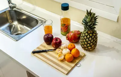 a cutting board with fruit on a counter next to a sink at Spacious Rooftop Apt in Central Athens with Sunset Balcony in Athens