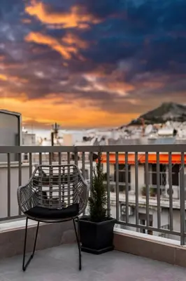 a chair and a potted plant on a balcony at Spacious Rooftop Apt in Central Athens with Sunset Balcony in Athens