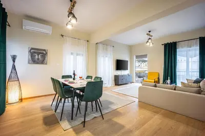a living room with a table and chairs and a couch at Spacious Rooftop Apt in Central Athens with Sunset Balcony in Athens