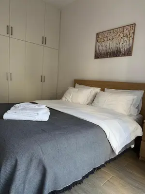 a bedroom with a large bed with white sheets at Piraeus 2 bedrooms apartment in Piraeus